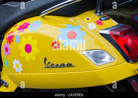 Un giallo brillante Piaggio Vespa scooter nel centro di Londra, Regno Unito Foto Stock