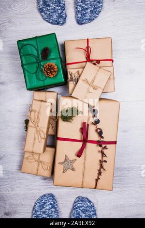 Classy regali di Natale scatola presenta con belle decorazioni e con i piedi sul pavimento. Composizione d'inverno. Foto Stock