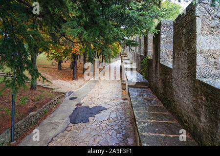 Vicolo pedonale, percorso in autunno parco con alberi colorati e muro di pietra Foto Stock