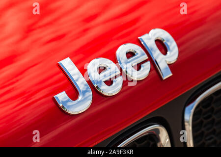 San Pietroburgo, Russia - Agosto 13, 2018: Cromato auto Jeep logo montato a rosso auto SUV cofano, foto macro con morbida messa a fuoco selettiva Foto Stock