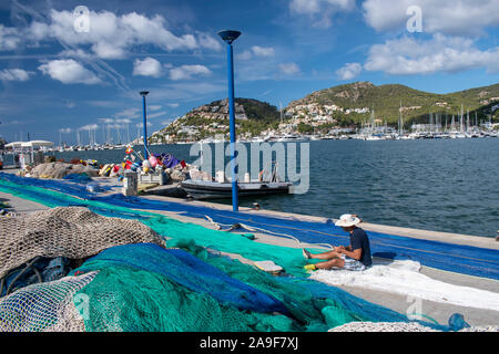 Port d'Andratx, Maiorca, Spagna, 16 ottobre 2019, la vista del porto di Andratx con reti stabilite in primo piano con una persona rammendo a loro. Foto Stock