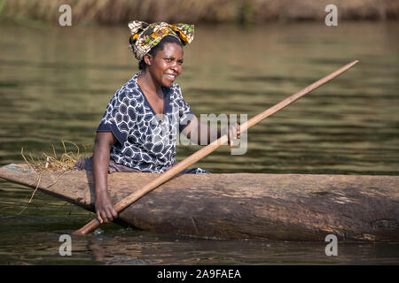 Batwa donna in piroga, nel Bunyonyi e lago, Uganda Foto Stock