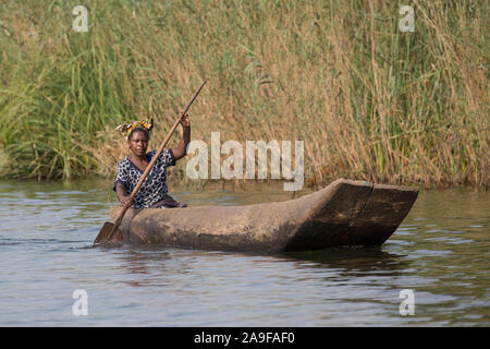 Batwa donna in piroga, nel Bunyonyi e lago, Uganda Foto Stock