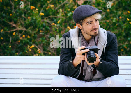 Ritratto di Hipster Street fotografo tenendo la fotocamera Mirrorless Foto Stock