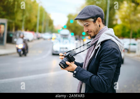 Hipster Street fotografo Riesame di foto sulla fotocamera Mirrorless Display Foto Stock