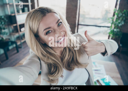 Primo piano della bella bionda signora business chief persona tenendo selfies sollevando il pollice fino del processo di lavoro poco corporate break convenzionale blazer Foto Stock