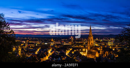 Germania, XXL panorama di Freiburg im Breisgau skyline dal di sopra nel post-incandescenza magica luce del tramonto di notte Foto Stock