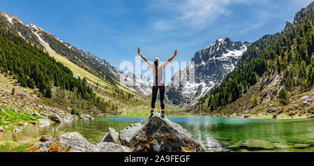 Donna in vincitore pongono su una roccia in un lago di montagna Foto Stock