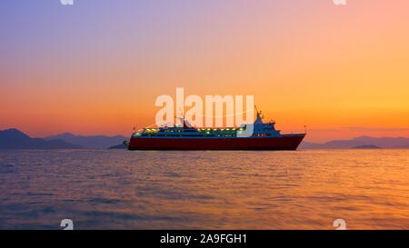 Nave in mare al tramonto - paesaggi marini. Lunga esposizione. La nave è un po' sfocata in movimento! Foto Stock