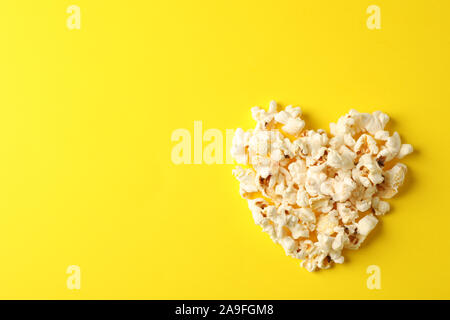 Piano di composizione dei laici con popcorn cuore su sfondo giallo, spazio per il testo Foto Stock