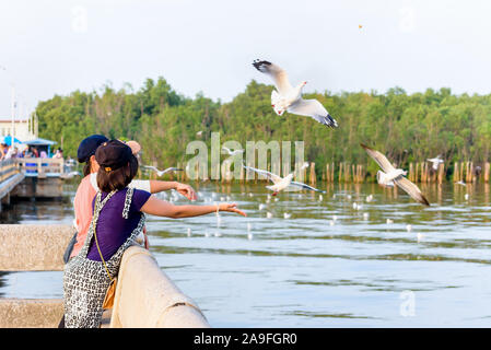 Donna e bambina famiglia asiatica tourist, madre e figlia sono happy fun alimentando i gabbiani volare sopra il mare, viaggio Asia di ricreazione Bangpu Cen Foto Stock