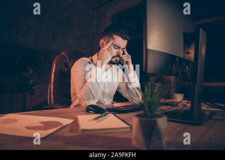 Foto di un uomo che soffre di mal di testa insopportabile sensazione di dolore estremo seduti davanti a schermo e non si riesce a terminare il suo lavoro Foto Stock