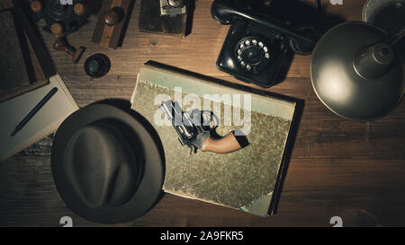 Noir anni cinquanta detective stile vintage desktop con il revolver fedora hat e telefono, laici piatta Foto Stock