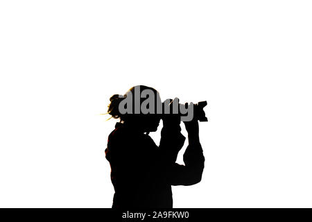 Silhouette di un fotografo di fronte a uno sfondo bianco Foto Stock