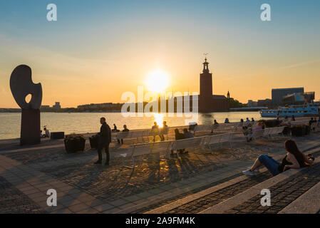 Riddarholmen e vista delle persone in estate rilassarsi sulla terrazza di fronte al mare, di Riddarholmen guardando il tramonto su Kungsholmen, Stoccolma centrale. Foto Stock