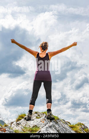 Silhouette femminile in posa di vittoria su un pinnacolo Foto Stock