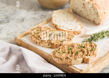 Freschi Fatti in casa di fegato di pollo patè. Fegato di pollo pate sul pane e nel vaso su uno sfondo luminoso. Foto Stock