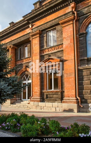 Il vecchio edificio di due piani del XIX secolo fatta di tufo nero decorato con tufo rosso nel classico stile su Abovyan street a Gyumri Foto Stock