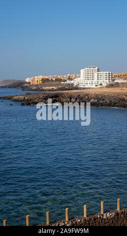 Estate chiaro vistas verso San Blas e Golf del Sur, popolare località del sud di Tenerife, come si vede dalla Playa Grande nel piccolo villaggio di Los Abrigos Foto Stock