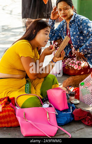 Un visitatore di sesso femminile di applicare il make up presso la Pagoda Kuthodaw, Mandalay Myanmar. Foto Stock