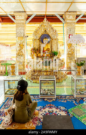 Una giovane donna orante presso la Pagoda Kuthodaw, Mandalay Myanmar. Foto Stock