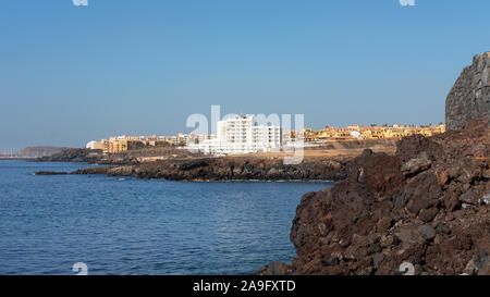 Estate chiaro vistas verso San Blas e Golf del Sur, popolare località del sud di Tenerife, come si vede dalla Playa Grande nel piccolo villaggio di Los Abrigos Foto Stock