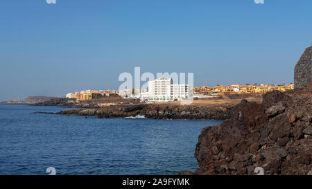 Estate chiaro vistas verso San Blas e Golf del Sur, popolare località del sud di Tenerife, come si vede dalla Playa Grande nel piccolo villaggio di Los Abrigos Foto Stock