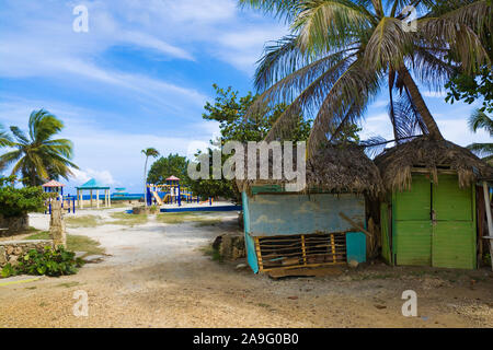 Sgangherate cottage di legno sulla costa del mare, la comunità del parco situato su Ocean cliff in background, Boca de Yuma, Repubblica Dominicana Foto Stock