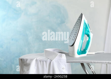 Ferro da stiro e camicia sul tavolo da stiro, spazio per il testo Foto  stock - Alamy