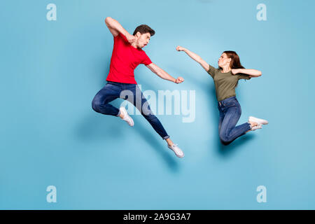 Full Size foto di uomo pazzo due persone donna uomo coniugi in disaccordo jump lotta kick boxing usura rosso verde t-shirt jeans denim sneakers isolate su Foto Stock