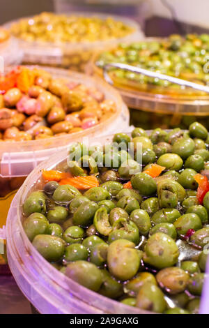 In casa decapati olive verdi con aglio e spezie in cucchiaio sul mercato spagnolo Foto Stock