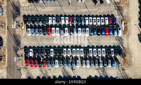 Un' antenna / drone vista di una concessionaria auto e parcheggio con le vetture schierate fianco a fianco. Foto Stock