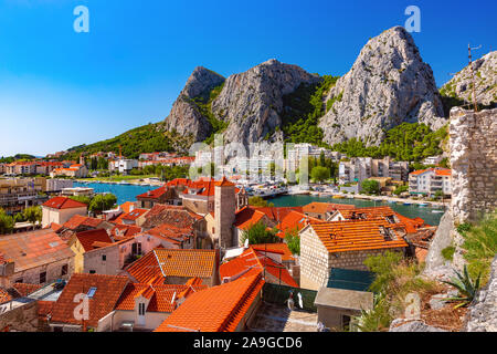 Sunny bella vista aerea del fiume Cetina, le montagne e i tetti della città vecchia in Omis, molto popolare meta turistica in Croazia Foto Stock