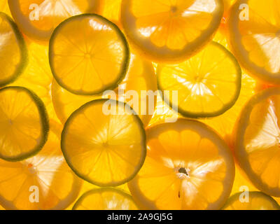 Orange limone fettine di lime accesa da sotto Foto Stock