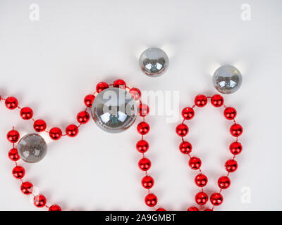 Perline rosso sfera trasparente giacciono su uno sfondo bianco. Foto Stock