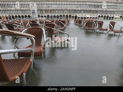 Molte sedie marroni sull'acqua durante il record alta marea a Venezia in Italia Foto Stock
