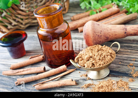 Olio di cannella e bastoni con polvere Foto Stock