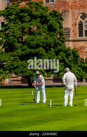 Riproduzione di croquet sul prato del Palazzo episcopale di Wells Somerset Foto Stock