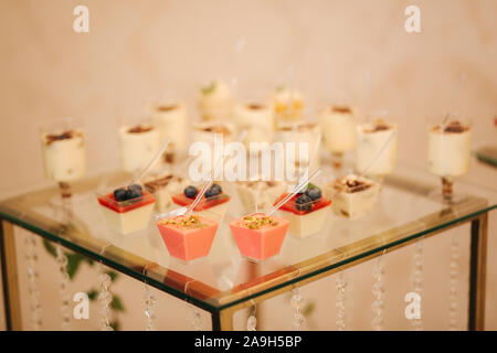 Diversi dessert sul tavolo di vetro. dolce. Foto Stock