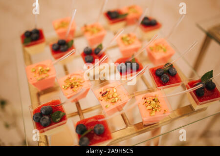 Diversi dessert sul tavolo di vetro. dolce. Foto Stock