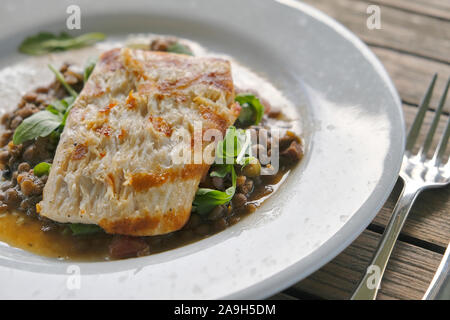 Grigliata di Mahi Mahi, oltre le lenticchie per la cena su una piastra bianca a Bud e vicolo del ristorante in Seaside Florida, Stati Uniti d'America. Foto Stock