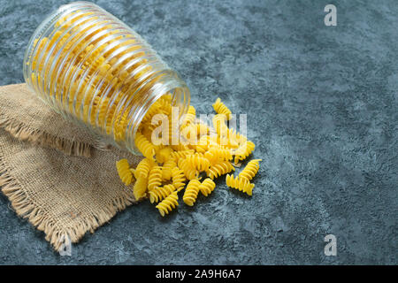 Pasta cruda in un vasetto di vetro su uno sfondo nero. Copia dello spazio. Foto Stock