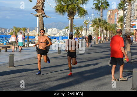 Fronte mare scena, la mattina presto vista del lungomare di Playa Levante Beach con passeggiate e jogging con cardiofrequenzimetro, Benidorm, Alicante Prov Foto Stock