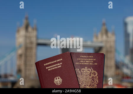 Mano che tiene il passaporto britannico insieme con altri passaporto UE contro il simbolo di Londra. Il viaggio dopo Brexit. Foto Stock