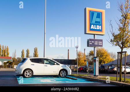 La Nissan Leaf a emissioni zero auto elettrica essendo addebitato al ALDI stazione di carica, Sopron, Ungheria Foto Stock