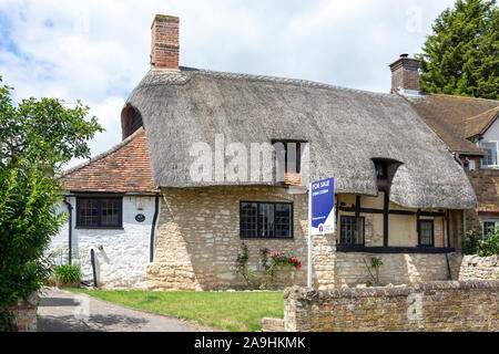 Cottage con il tetto di paglia per la vendita, High Street, Long Crendon, Buckinghamshire, Inghilterra, Regno Unito Foto Stock