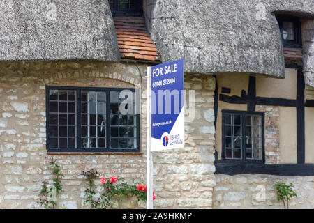 Cottage con il tetto di paglia per la vendita, High Street, Long Crendon, Buckinghamshire, Inghilterra, Regno Unito Foto Stock