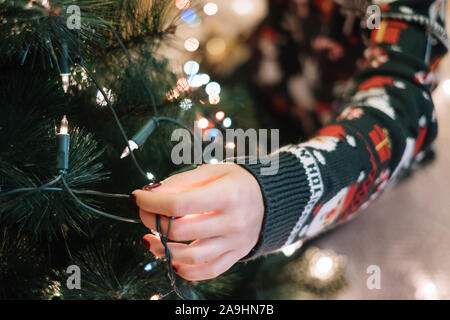 Femmine di decorazione a mano albero di Natale con luci Foto Stock