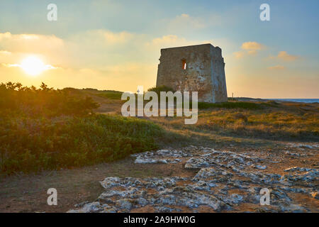 Ruderi della Torre Pozzelle un antica torre di avvistamento costiero in un colorato tramonto Ostuni Puglia Italia. Foto Stock