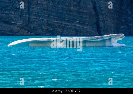 Tavolo a forma iceberg galleggia in acque turchesi in Montana lago Foto Stock